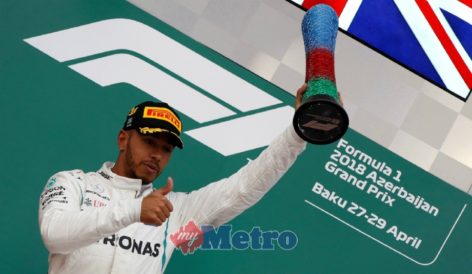 LEWIS Hamilton menjulang trofi dan menunjukkan isyarat bagus selepas memenangi perlumbaan GP Azerbaijan di Baku. - FOTO Reuters