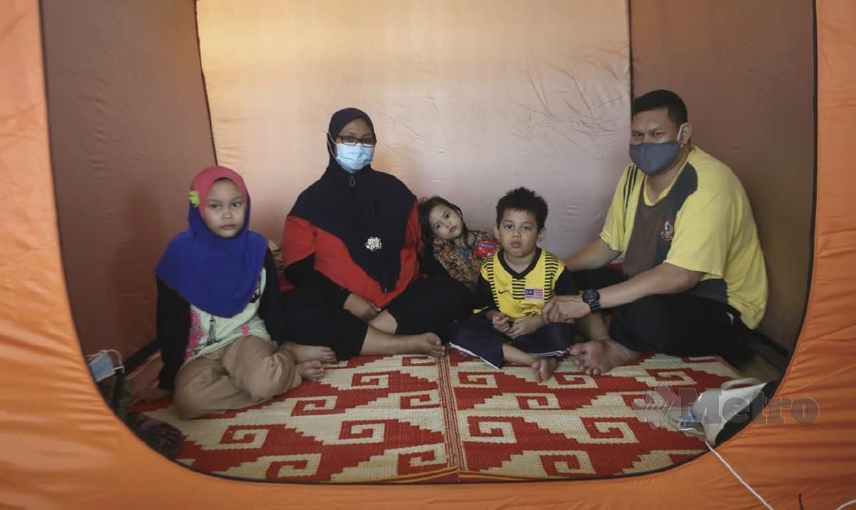HASLINI (dua kiri) bersama tiga anak serta suaminya di PPS di Sekolah Kebangsaan Tok Jembal. FOTO GHAZALI KORI