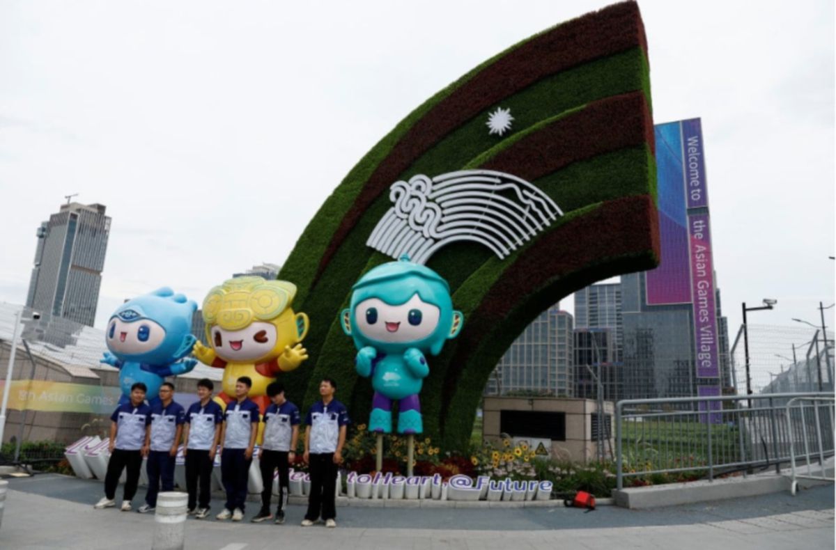SUKARELAWAN bergambar di depan tugu tiga maskot temasya Sukan Asia Hangzhou 2022 berdekatan dengan Perkampungan Sukan Asia. FOTO Reuters