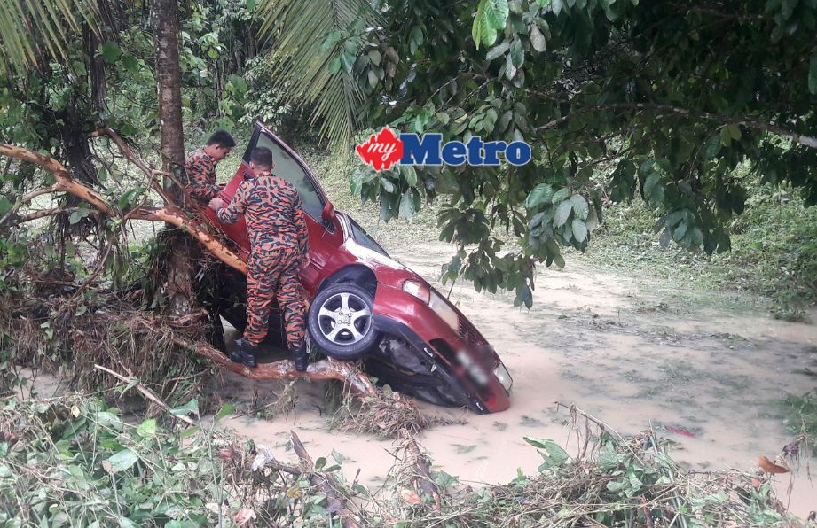 Anggota Bomba dan Penyelamat Kuala Pilah memeriksa kereta yang dihanyutkan banjir yang hampir meragut nyawa dua wanita. FOTO Amran Yahya 