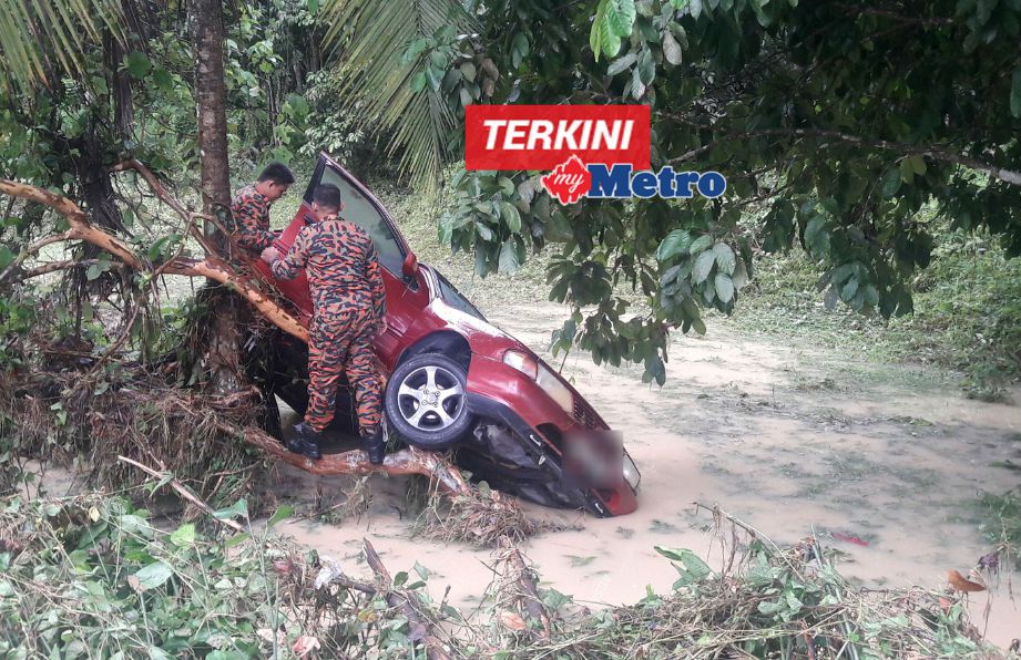 Anggota Bomba dan Penyelamat Kuala Pilah memeriksa kereta yang dihanyutkan banjir yang hampir meragut nyawa dua wanita. FOTO Amran Yahya