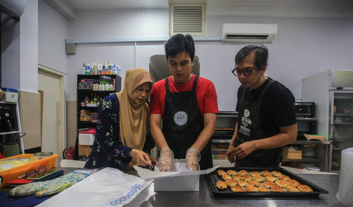 LUQMAN membantu menyediakan roti dan biskut untuk dijual ketika ditemui di Autisme Cafe Project. FOTO Genes Gulitah