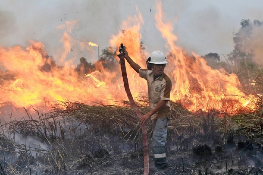 Anggota bomba yang menyertai usaha mengawal kebakaran di Ogan Ilir, Sumatera Selatan, semalam. - Foto AP