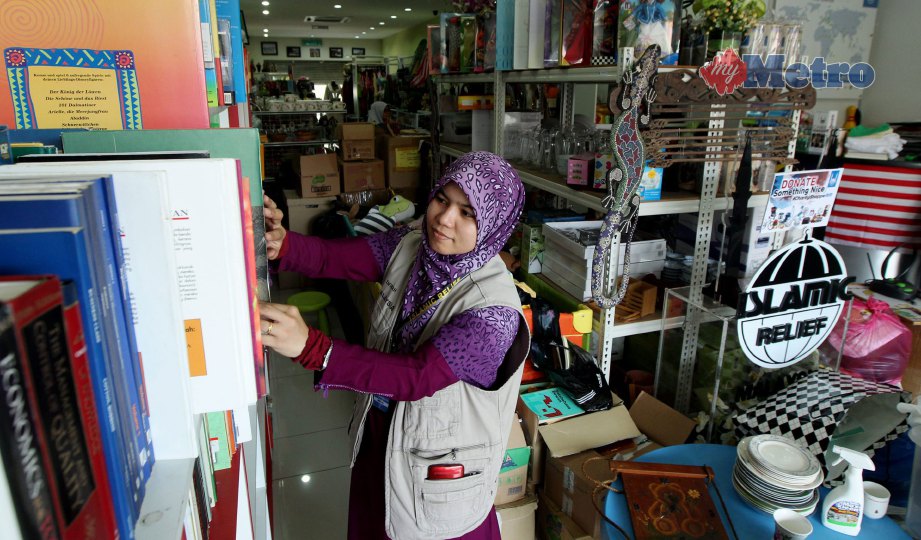 NOR Zafirah menyusun buku yang didermakan orang ramai di Charity Shoppe. FOTO Surianie Mohd Hanif 