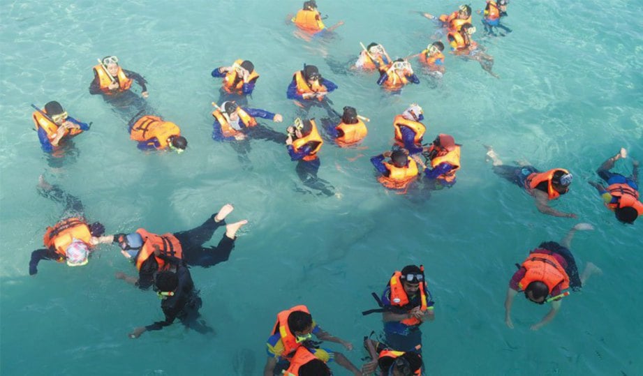 SEKUMPULAN pengunjung teruja mengadakan aktiviti ‘snorkeling’ bagi melihat ribuan spesies ikan jinak berenang di sekeliling badan.