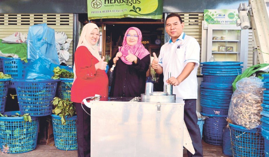 AZUKI, Rohana dan pegawai penyelidik FRIM Nik Zanariah Nik Mahmood bersama mesin pemprosesan herba mengkudu, inovasi Herbagus Sdn Bhd yang mendapat anugerah TRIS.