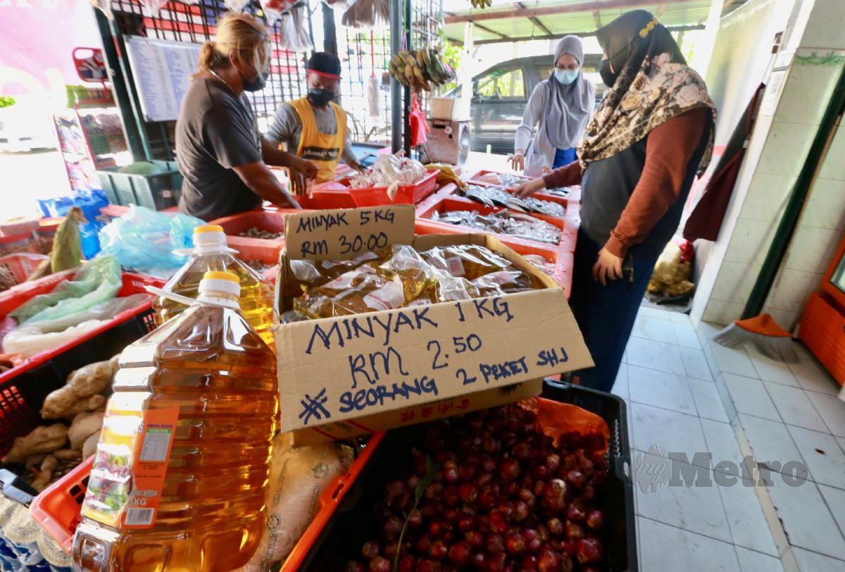 Tinjauan di sebuah kedai runcit mendapati peniaga menjual minyak masak 5kg dengan RM30 manakala minyak paket, pelanggan hanya dibenarkan membeli 2 paket dengan harga RM2.50. FOTO FATHIL ASRI.
