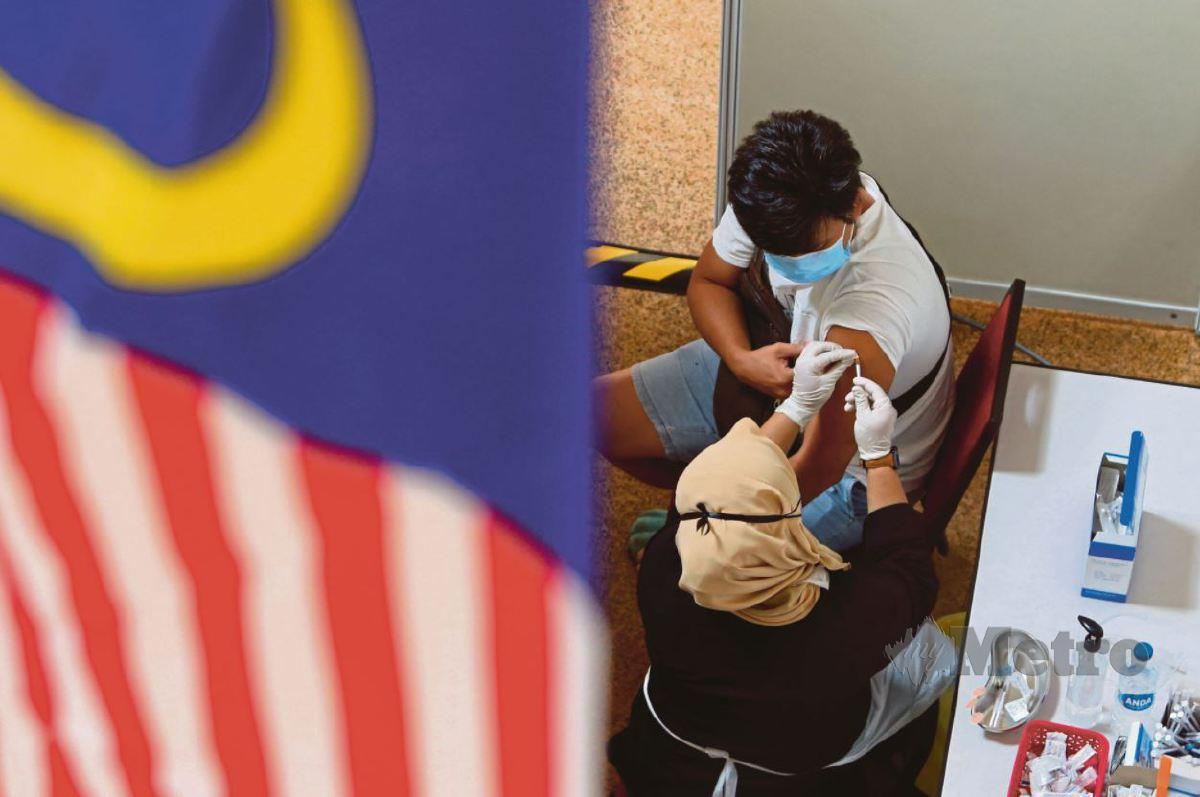 Petugas kesihatan memberi suntikan vaksin kepada penerima di PPV RiVAC Dataran Pahlawan Melaka Megamall. FOTO Syafeeq Ahmad.