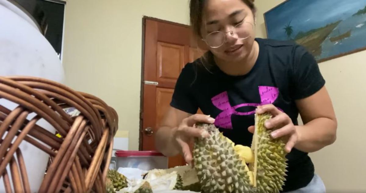 GELAGAT Hidilyan mengopek durian di Jasin.
