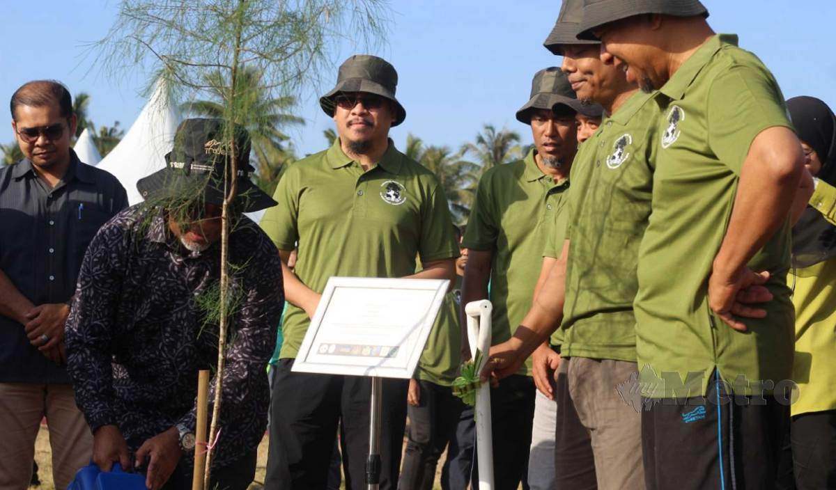 ABDUL Rahman (dua kiri) menyiram pokok Rhu di Pantai Baru, Melawi, Bachok. FOTO Nor Amalina Alias