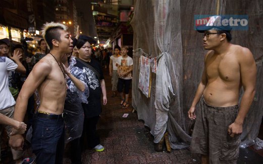 DUA aktivis prodemokrasi berselisih faham mengenai penghadang jalan raya di Mong Kok, Kowloon.