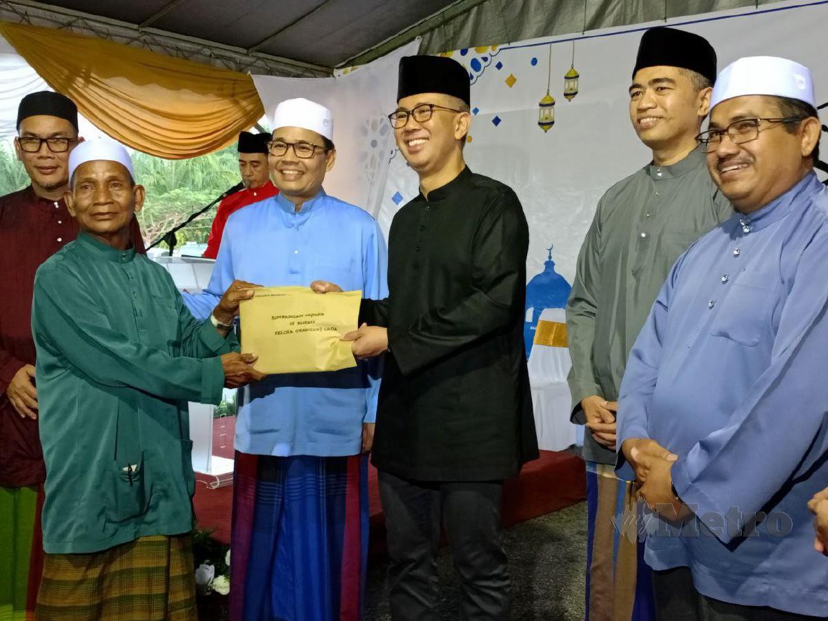 Menteri Pelaburan, Perdagangan dan Industri, Datuk Seri Tengku Zafrul Tengku Abdul Aziz (tiga dari kanan) menyerahkan sumbangan kepada dua masjid dan 11 surau di dalam kawasan Seberang Perak. - FOTO NSTP