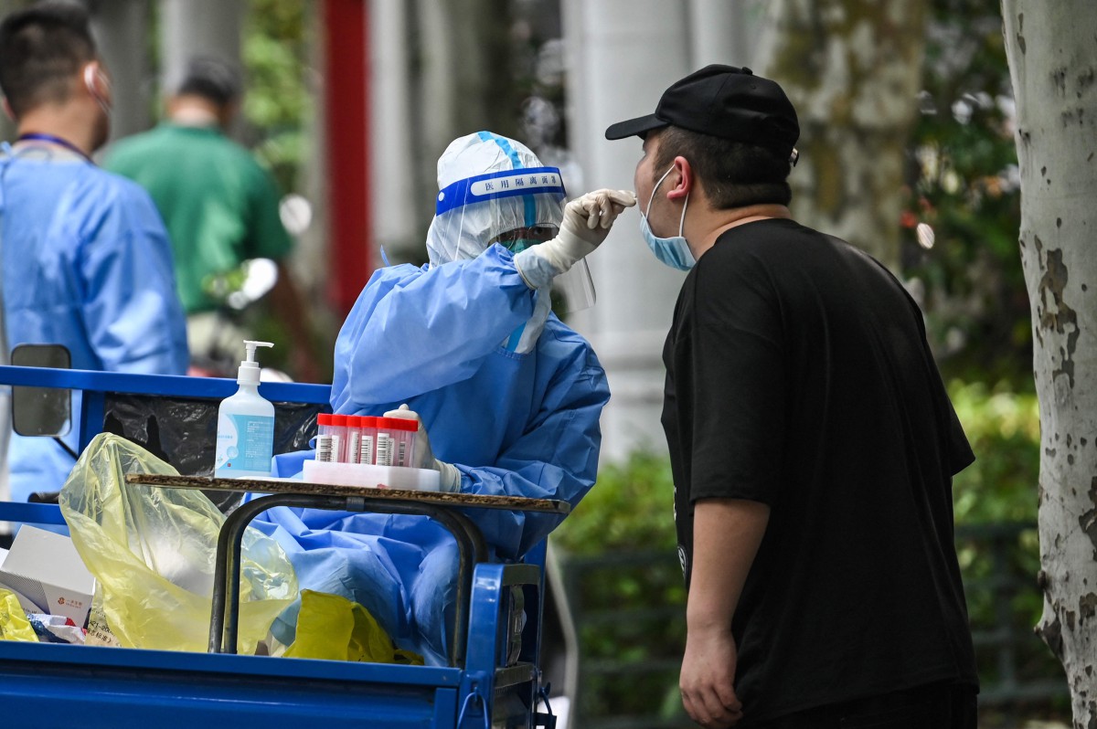 Seorang pekerja kesihatan melakukan ujian calitan di Jing’an, Shanghai. - FOTO AFP