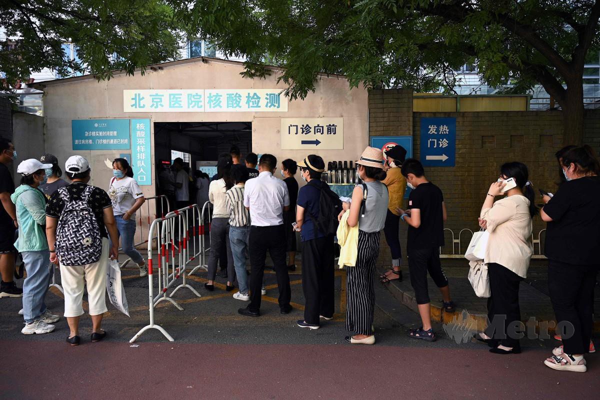 Orang ramai beratur di hospital di Beijing, China untuk ujian pengesanan Covid-19. - FOTO AFP