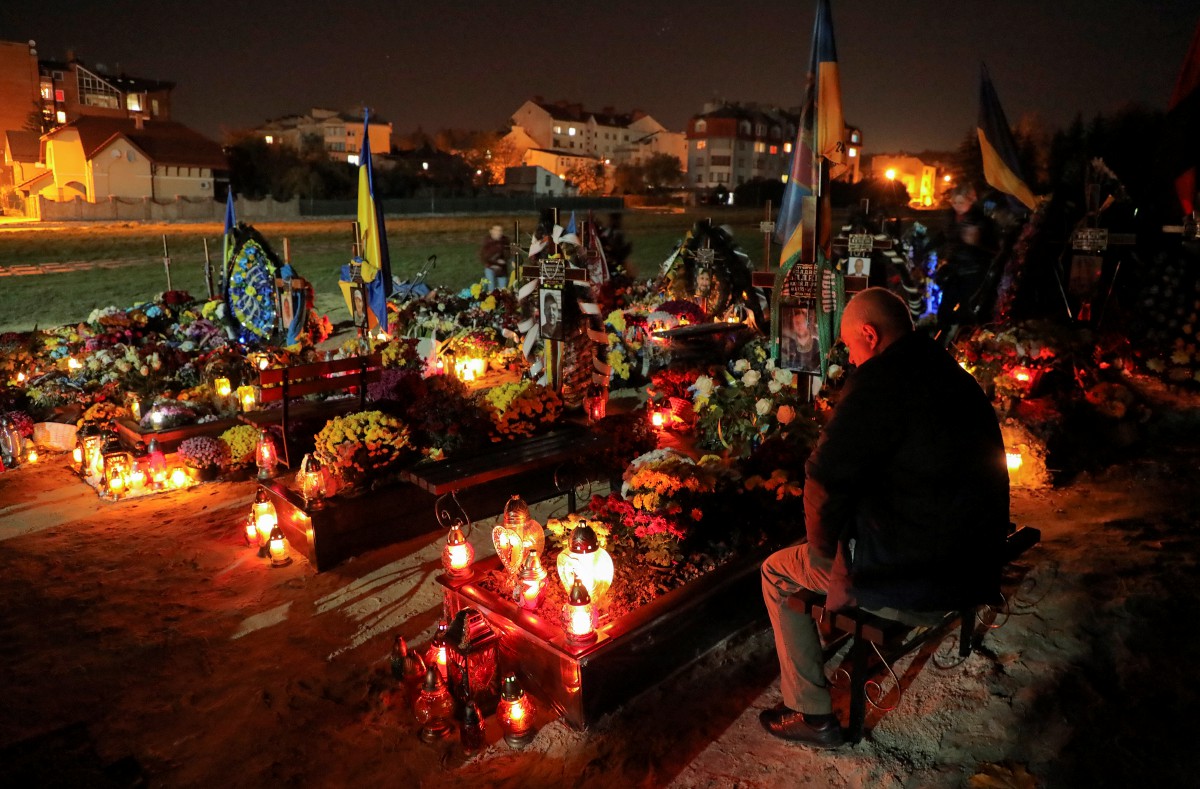 Warga Ukraine menyalakan lilin bagi memperingati tentera yang terkorban. - FOTO EPA