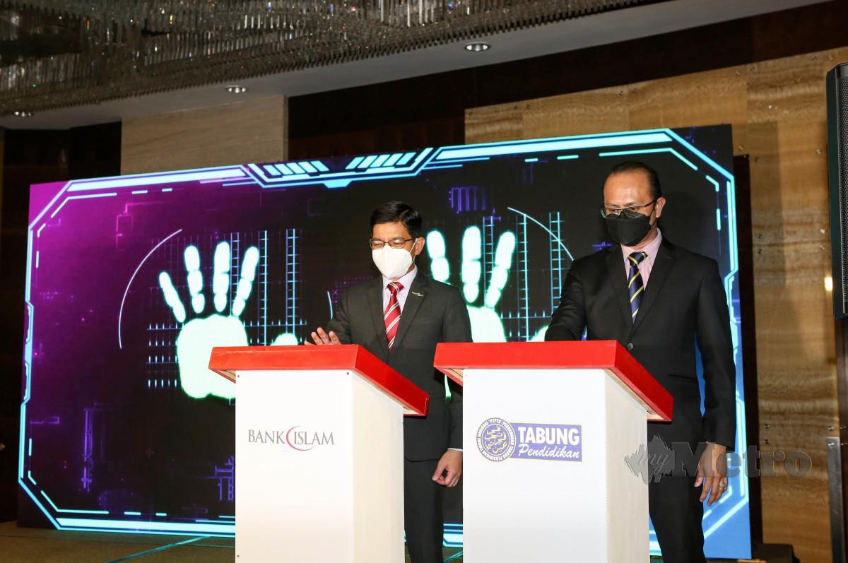 MOHD Muazzam bersama Ahmad Dasuki (kanan) melancarkan simbolik pelancaran 'Pay & Win With DD (DirectDebit) dan penyerahan zakat perniagaan Bank Islam bagi tahun 2020 kepada PTPTN. FOTO Hazreen Mohamad