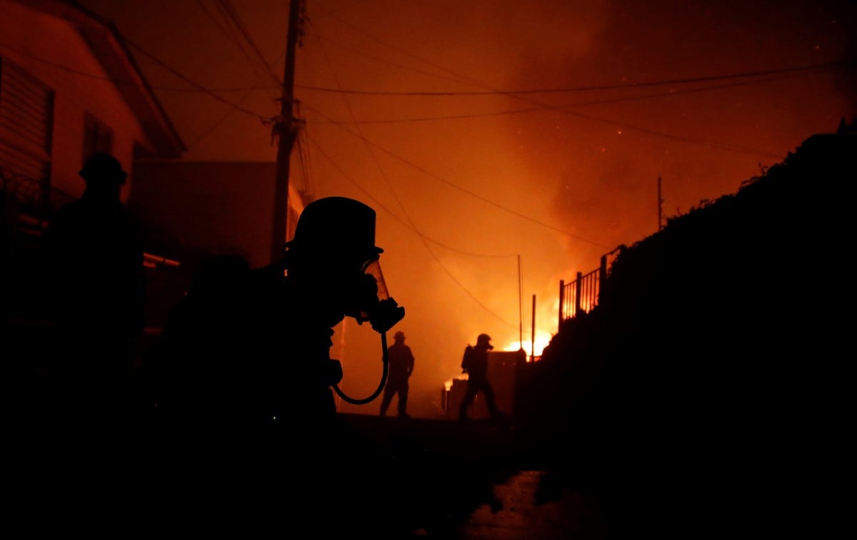 Anggota bomba memadamkan kebakaran di Viña del Mar, Chile. - FOTO AFP