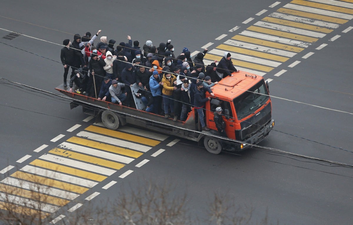 Penunjuk perasaan menaiki trak sekitar bandar Almaty. - FOTO Reuters