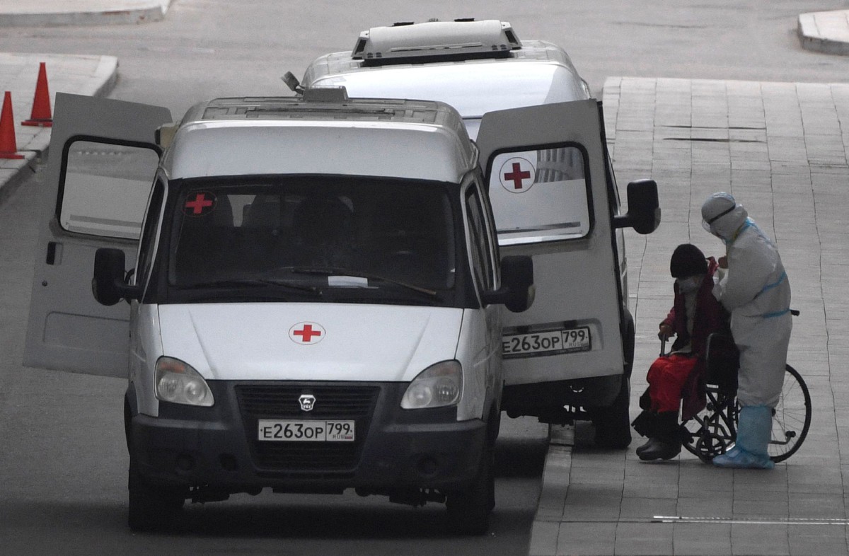 Kakitangan perubatan membantu pesakit di bahagian rawatan Covid-19 di Hospital Kommunarka, Moscow. - FOTO AFP