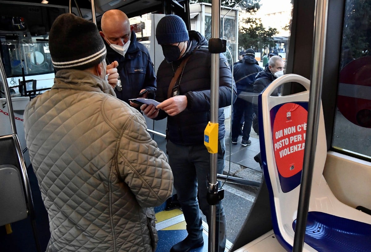 Anggota penguatkuasa memeriksa kod QR penumpang bas bagi memastikan mereka sudah mendapatkan vaksin Covid-19 di hentian bas di Genoa, Itali. - FOTO EPA