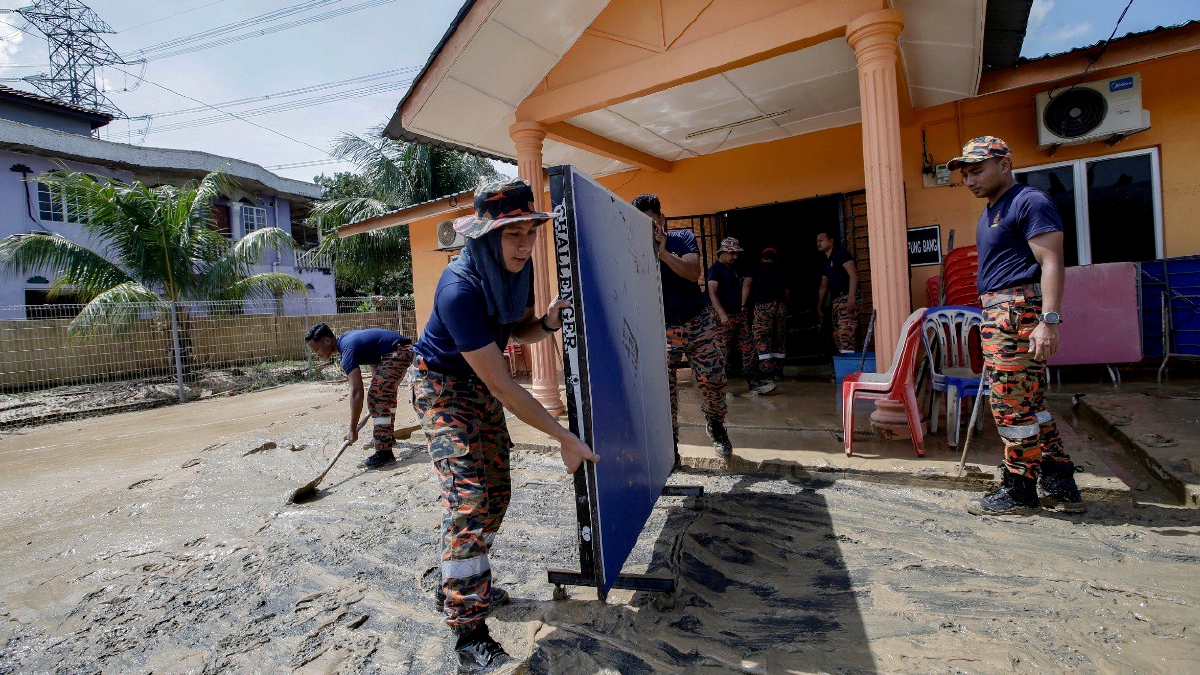 ANGGOTA Jabatan Bomba dan Penyelamat dari Balai Bomba Bangi membantu membersihkan Balai Raya Kampung Bangi yang ditenggelami banjir berpunca dari air Sungai Bangi yang melimpah akibat hujan lebat ketika tinjauan pasca banjir di Kampung Bangi Tambahan, Bangi, semalam. FOTO Aizuddin Saad