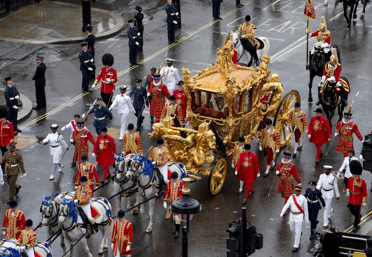 Raja Charles III dan Permaisuri Camilla dibawa menaiki kereta kuda Gold State Coach yang dibina pada 1760 dan digunakan pada setiap upacara pertabalan sejak William IV pada 1831. - FOTO Reuters