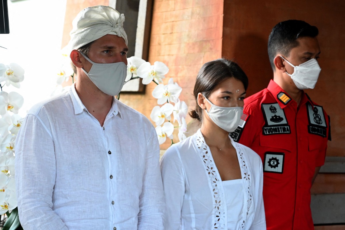 Alina Fazleeva (tengah) dan suaminya, Amdrei Fazleev (kiri) diusir dari Bali dan dilarang masuk ke Indonesia sekurang-kurangnya selam enam bulan. - FOTO AFP