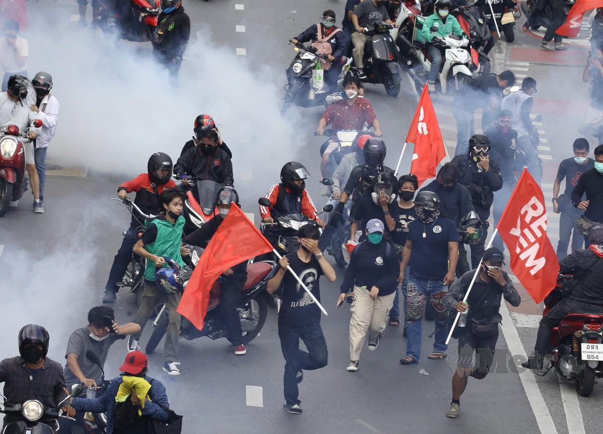 Polis melepaskan gas pemedih mata ke arah peserta demonstrasi di Bangkok. - FOTO EPA