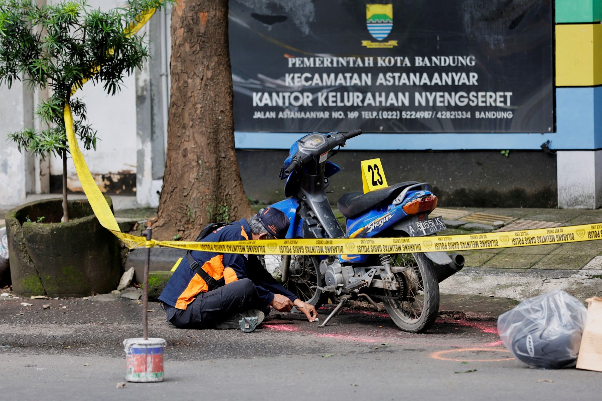 Pegawai keselamatan mendapatkan bukti dari motosikal dipercayai milik pengebom. - FOTO Reuters