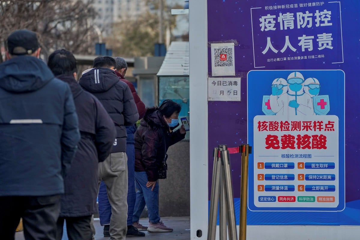 Seorang wanita menunjukkan kod QR pas kesihatannya sebelum menjalani ujian calitan di Beijing. - FOTO AP