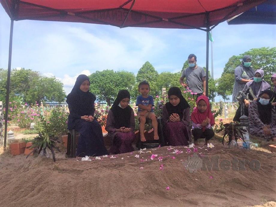 LIMA anak kepada Zuriana Hassan,35 mengirimkan doa selepas pengebumian ibu mereka di Tanah Perkuburan Islam Bagan, Jermal, Butterworth. FOTO Nur Izzati Mohamad