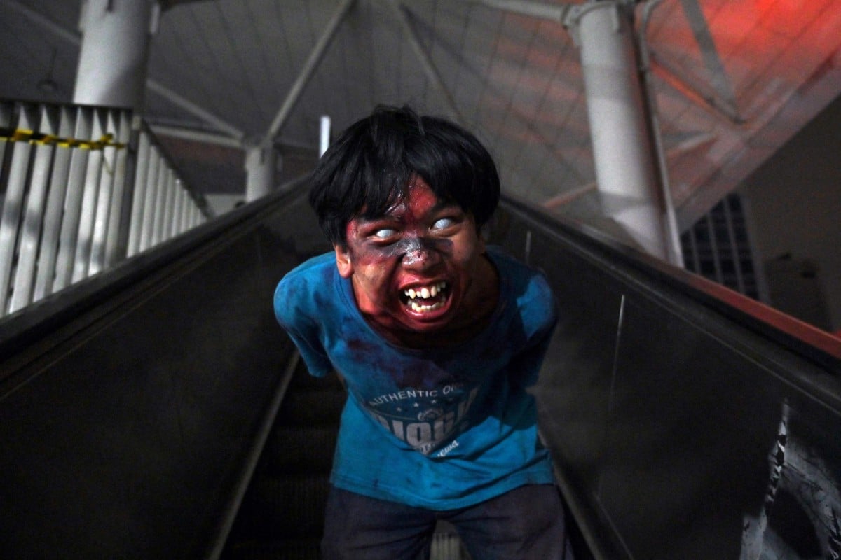 Seorang lelaki berlakon sebagai zombie di stesen LRT di Jakarta. - FOTO AFP