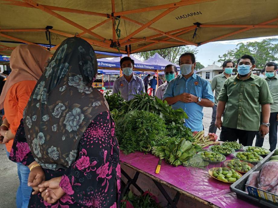 AZMAN, (tengah kemeja biru muda) meninjau jualan peniaga di Pasar Segar Terkawal di Pusat Operasi FAMA Sungai Petani, di sini. FOTO Nor Farhani Che Ad