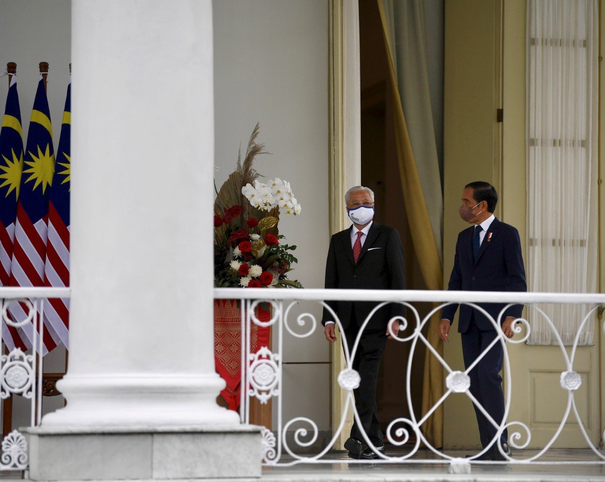 Perdana Menteri Datuk Seri Ismail Sabri Yaakob (kiri) berbual bersama Presiden Indonesia Joko Widodo menuju ke beranda Istana Bogor sebelum mesyuarat dua hala. - FOTO BERNAMA