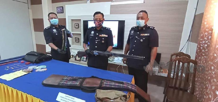 SUPERINTENDAN Mohd Khairiel Mohd Arif ( tengah ) menunjukkan senapang patah yang dirampas daripada suspek yang bertindak menyembunyikan senjata milik individu lain. FOTO Abnor Hamizam