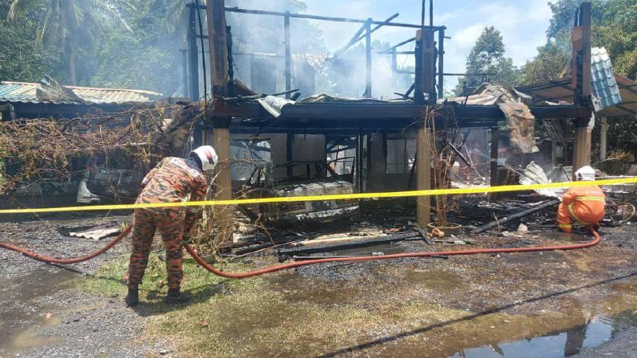 ANGGOTA bomba memadam kebakaran membabitkan sebuah rumah dan dua kereta dan tiga motosikal di Lorong Berjaya Kampung Pulau Kechil yang terbabit dalam kebakaran. FOTO ihsan BOMBA