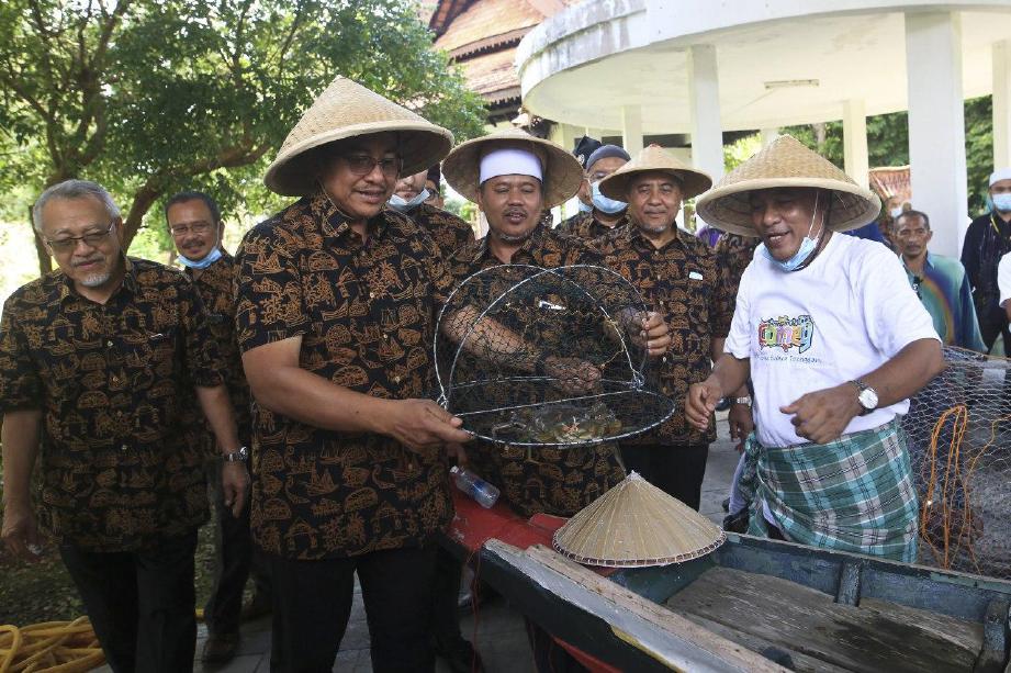 DATUK Seri Dr. Ahmad Samsuri (dua kiri) melihat cara pembuatan bubu tradisional pada majlis Pelancaran Kampung Budaya Terengganu (KBT) di Perkarangan Kompleks Lembaga Muzium Negeri Terengganu. FOTO Ghazali Kori