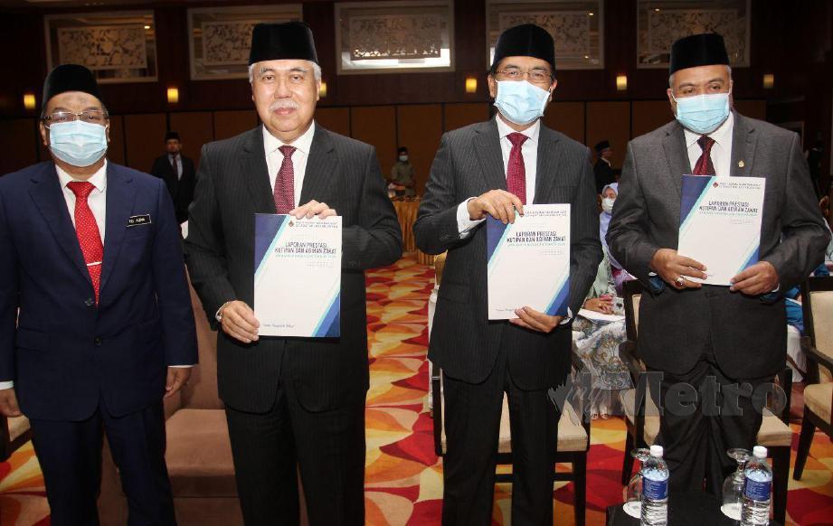 TAN Sri Tengku Mohamad Rizam Tengku Aziz (dua kiri) menunjukkan perutusan laporan Prestasi Kewangan. FOTO Nik Abdullah Nik Omar