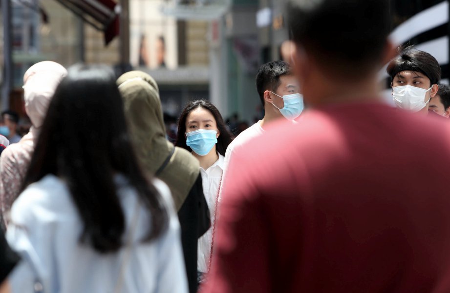 ORANG awam menggunakan pelitup muka setelah kerajaan mewajibkan penggunanya di tempat awam. FOTO Mohamad Shahril Badri Saali