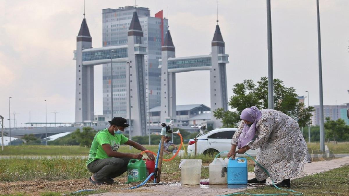 PENDUDUK mengisi air bersih yang disediakan oleh Syarikat Air Terengganu Sdn Bhd (SATU) ke dalam botol ekoran bekalan air terputus sejak seminggu lalu. FOTO GHAZALI KORI