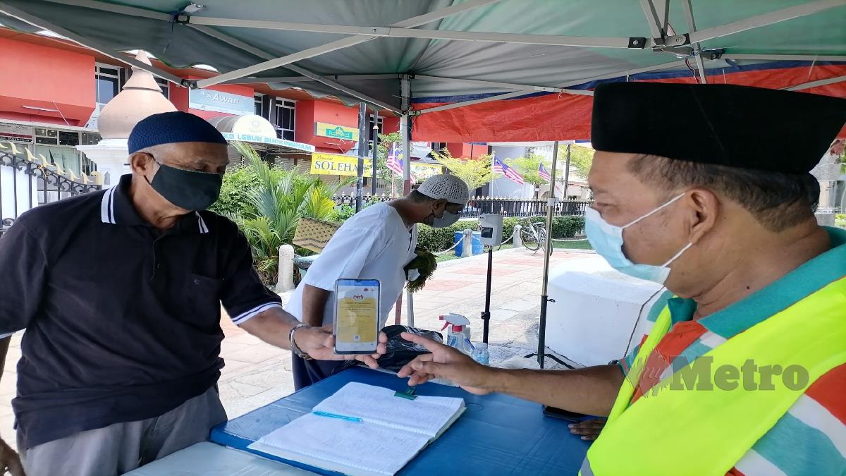 PIHAK pengurusan Masjid Kapitan Keling, Lebuh Buckingham memeriksa sijil digital vaksinasi Covid-19 jemaah sebelum memasuki masjid. FOTO ZUHAINY ZULKIFFLI