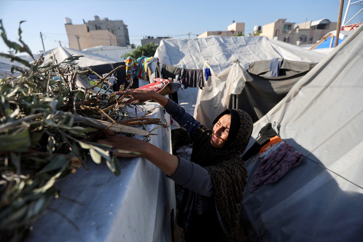 Seorang wanita menyesuaikan diri di kem pelarian di Khan Younis. - FOTO Reuters