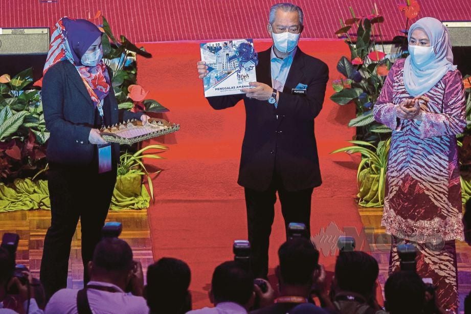 TAN Sri Muhyiddin Yassin menerima buku 'Menggalas Amanah : Mencarta Hala Tuju, Memahat Kewibawaan' dari Datuk Dr. Noraini Ahmad  (kanan) pada majlis pelancaran PENJANA di UKM. FOTO Asyraf Hamzah