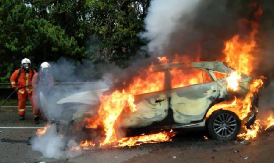 ANGGOTA Bomba Kluang berusaha memadamkan kebakaran yang berlaku keatas kereta Toyota Harrier selepas terlibat dalam kemalangan di Jalan Batu Pahat - Kluang berhampiran Kampung MIC Kluang Kira-kira jam 7.30 pagi tadi. FOTO ihsan BOMBA