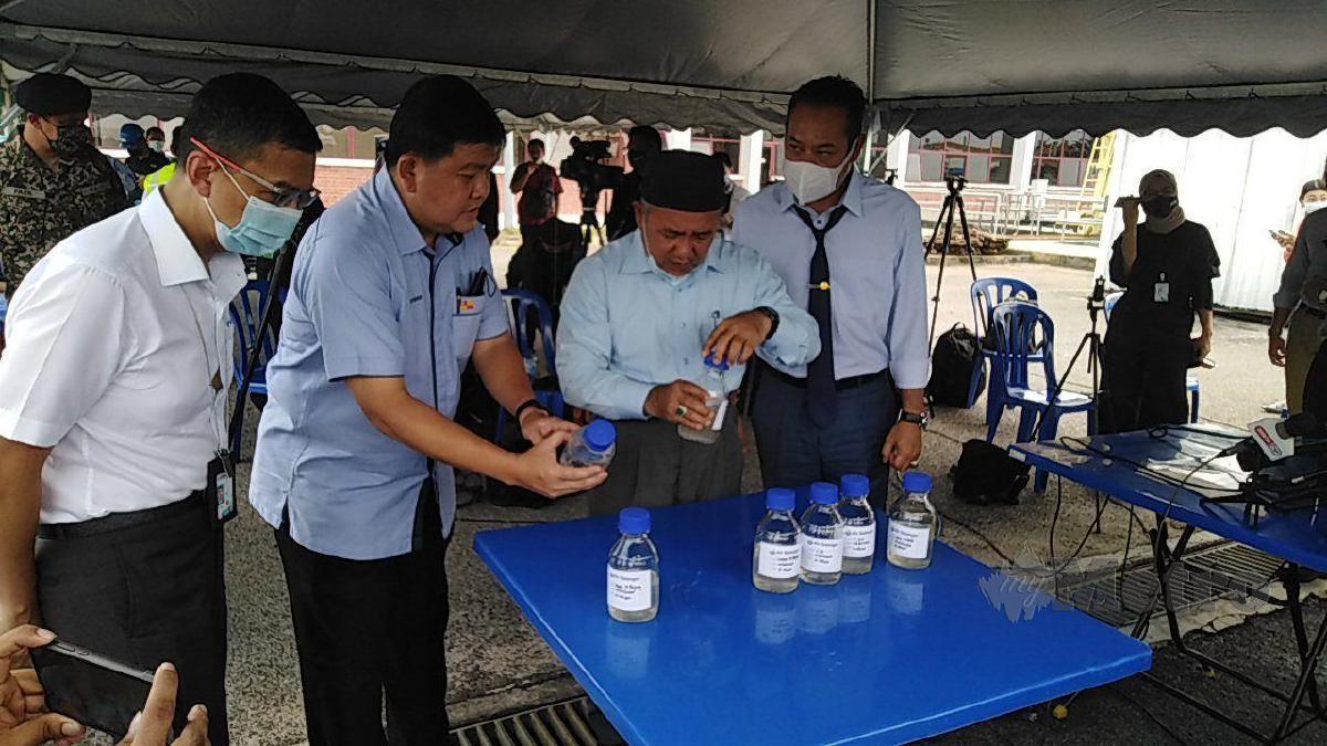 DATUK Seri Tuan Ibrahim (tengah) melihat sampel air yang tercemar sambil disaksikan Hee Loy Sian (dua dari kiri) dan Datuk Dr Ahmad Masrizal (kanan) di Loji Rawatan Air (LRA) Sungai Selangor. FOTO Amirul Aiman Hamsuddin