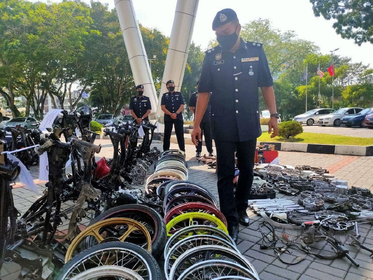 SUPERINTENDAN Mohd Redzuan Salleh menunjukkan rangka, komponen dan enjin motosikal curi yang ditemui di sebuah bengkel dalam serbuan Op Lejang Oktober lalu. FOTO Zuliaty Zukiffli