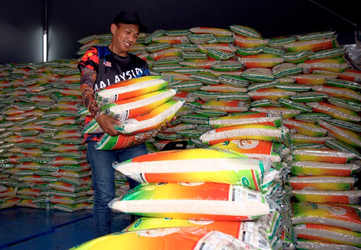 Seorang pekerja menyusun tiga kampit beras putih tempatan 10 KG yang dijual dengan harga RM26 pada Jualan Rahmah sempena Hari Peladang, Penternak dan Nelayan Kebangsaan (HPPNK) 2023 di Dataran Bulatan Sultan Azlan Shah Meru hari ini. FOTO BERNAMA