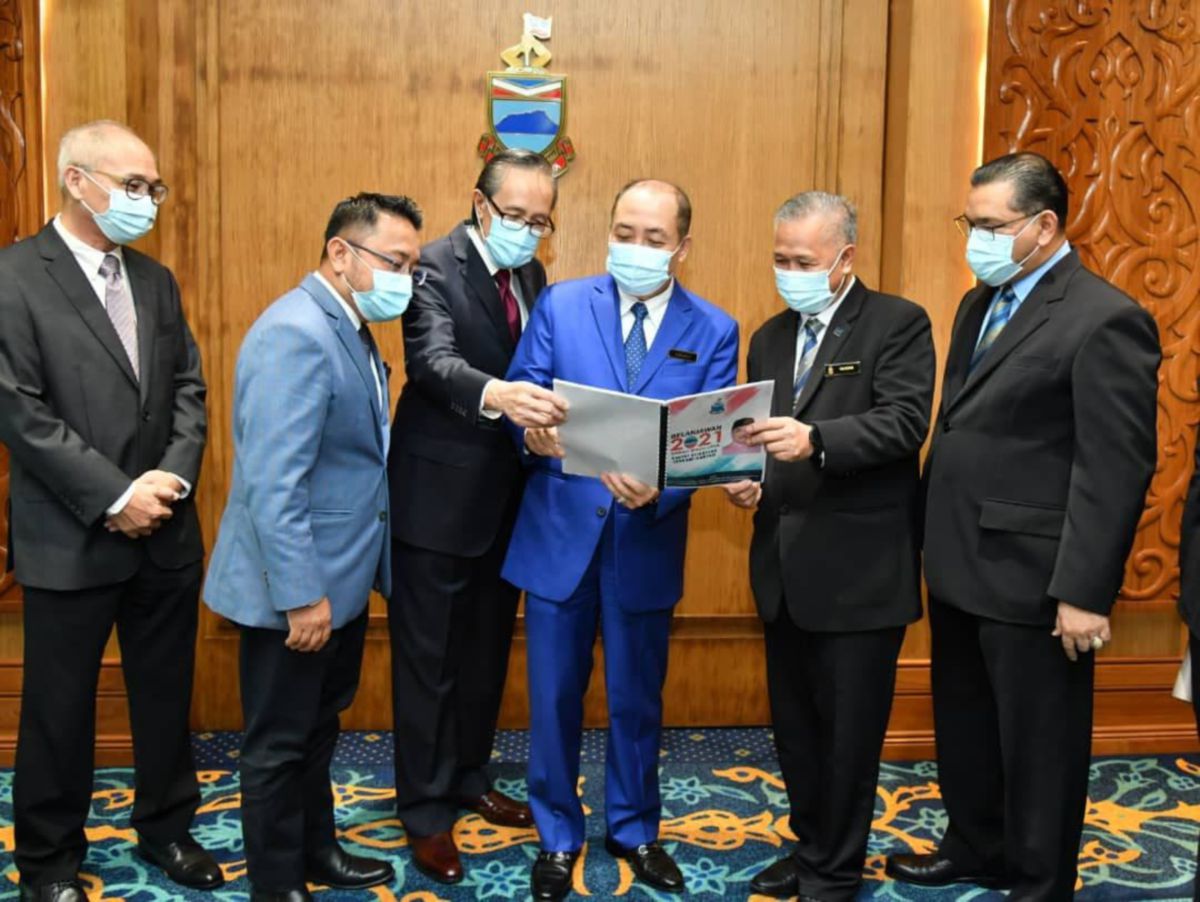 DATUK Hajiji Noor (tiga kanan) bersama Datuk Masidi Manjun (tiga kiri); Rusdin Riman (dua kanan); Datuk Nizam Abu Bakar Titingan (kanan) dan Jasni Daya (dua kiri) meneliti dokumen Belanjawan Sabah 2021. FOTO ihsan Jabatan Ketua Menteri Sabah
