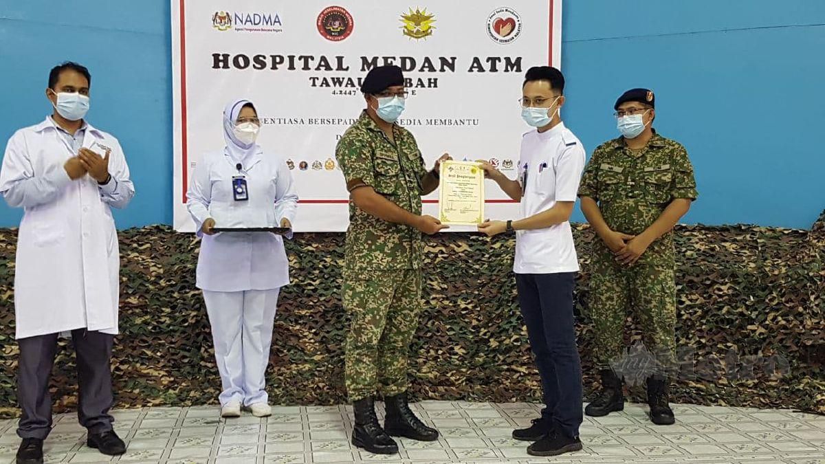 KOLONEL Dr Shamsul Bahary Muhamad menyampaikan sijil penghargaan kepada salah seorang jururawat yang akan menamatkan penugasan di hospital itu. FOTO Abdul Rahemang Taiming