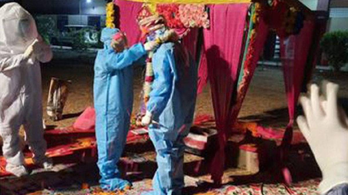 PASANGAN mempelai meraikan perkahwinan dalam sut PPE selepas pengantin perempuan disahkan positif Covid-19 beberapa jam sebelum majlis berlangsung. FOTO Agensi
